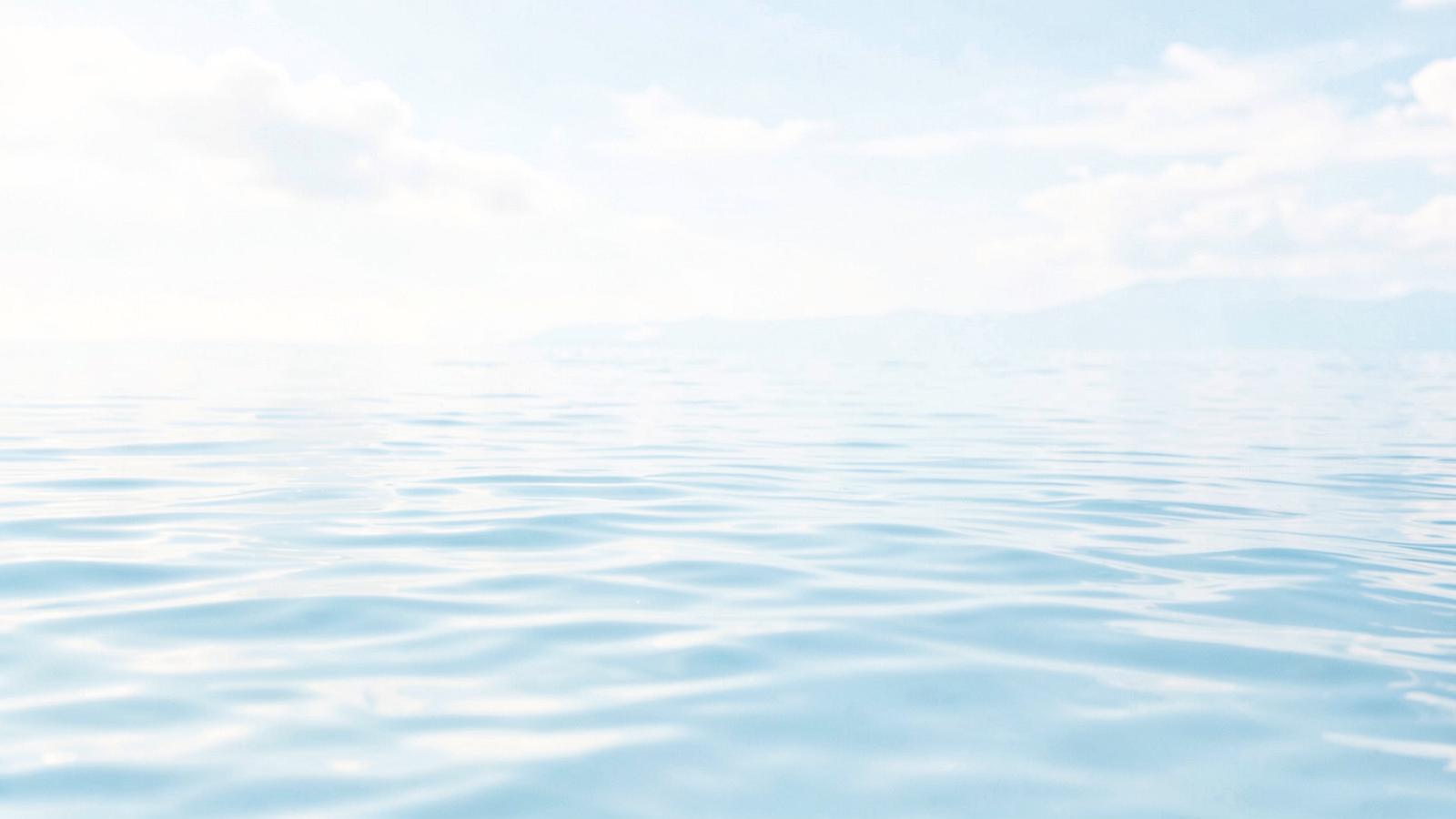 Soft ripples on pale blue water in morning light